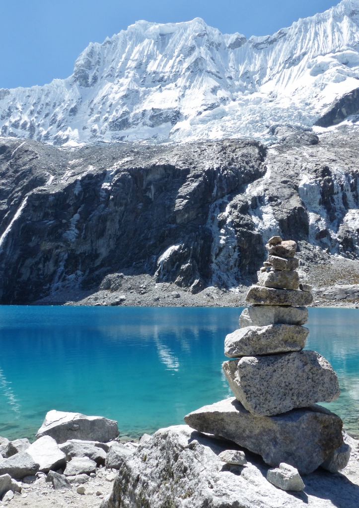 Vue sur la Laguna 69 avec un cairn au premier plan 