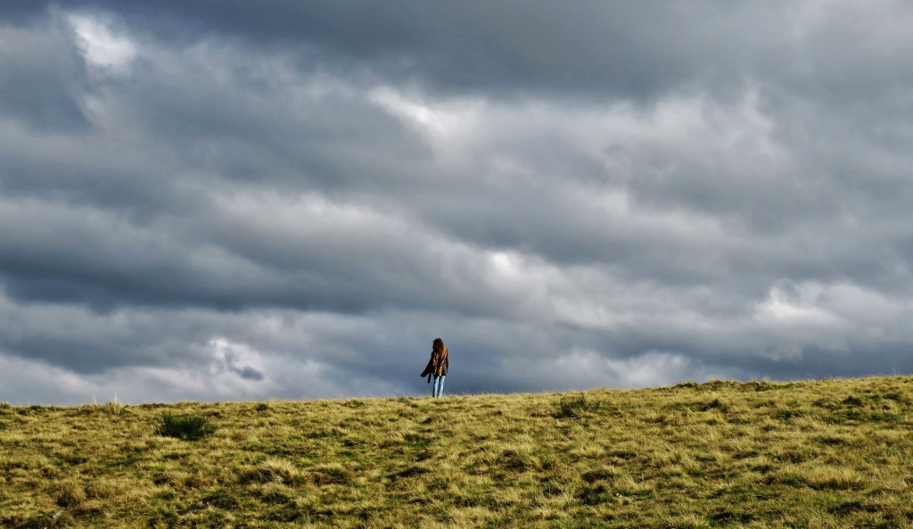 Randonneuse sous un ciel orageux en Auvergne