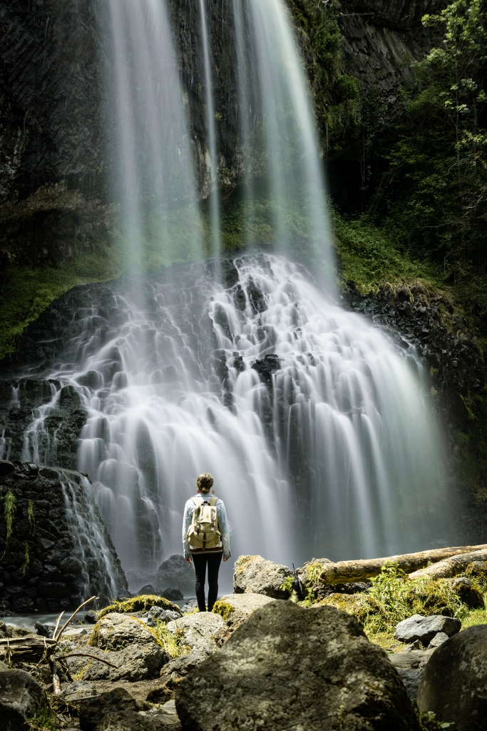 Femme de dos face à la cascade de la Beaume en Haute-Loire