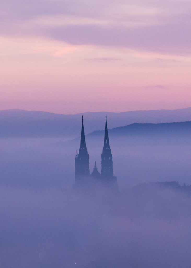 Vue sur les flèches de la cathédrale de Clermont-Ferrand dans une mer de nuages au lever du jour