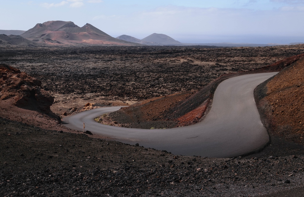 Les volcans du parc de Timanfaya à Lanzarote avec route au premier plan 