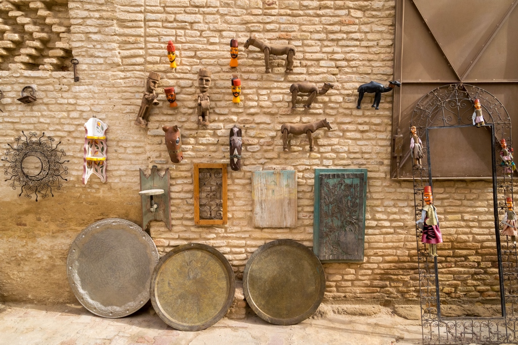 Vue sur l'artisanat tunisien accroché sur la façade d'une maison en briquette orange 