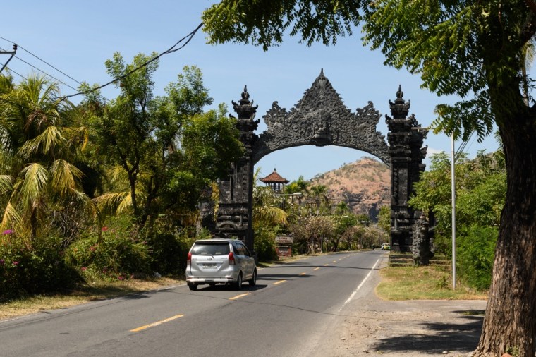 Route balinaise avec porte sculptée en pierre